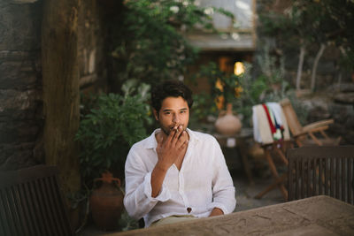 Portrait of young man sitting on table