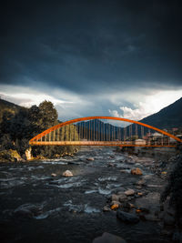 Bridge over river against sky at dusk