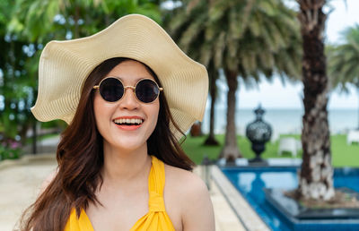 Portrait of smiling young woman wearing sunglasses