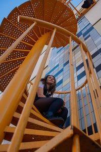 Low angle view of woman sitting outdoors
