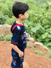 Side view of boy standing on field