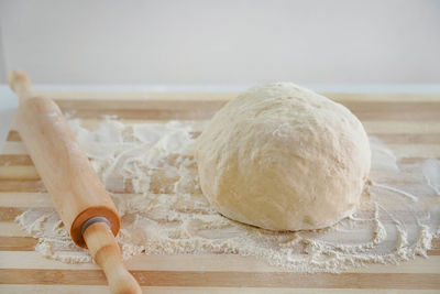 Rolling pin and dough on wooden table with flour. basic needs and rising of prices concept.