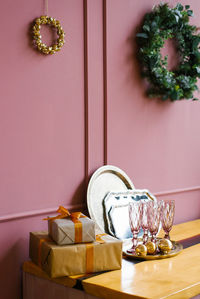 Pink glass glasses, gift box christmas tree wreath, metal trays in the pink kitchen. christmas decor