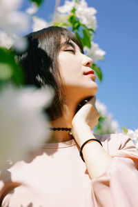 Low angle view of woman against blue sky