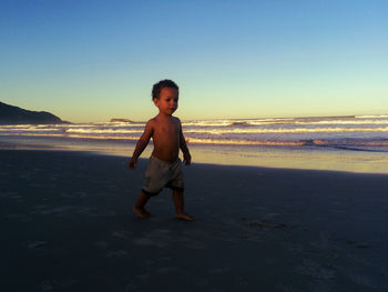 Full length of boy on beach against sky