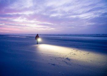 Scenic view of beach against cloudy sky