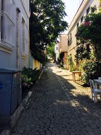 Walkway by street in city against sky