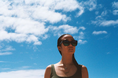 Low angle view of man wearing sunglasses against sky