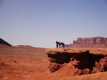 Man on cliff against sky