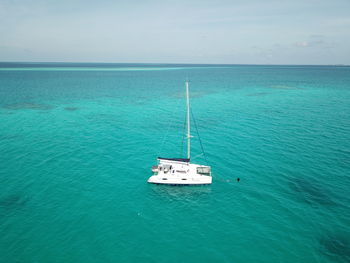 Sailboat sailing in sea against sky