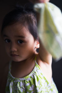 Close-up portrait of cute girl holding mask
