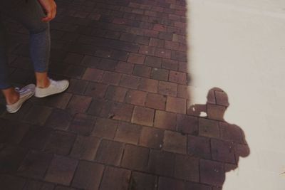 Low section of woman standing on tiled floor