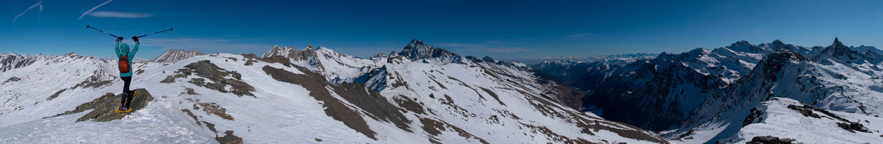 Panoramic view of snowcapped mountains against blue sky