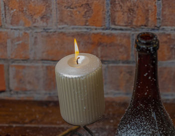 Close-up of candles on table against wall