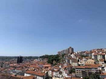 Buildings in city against clear blue sky