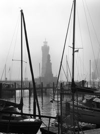 Boats moored at harbor against sky