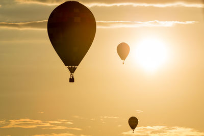 Hot air balloons flying against sky during sunset