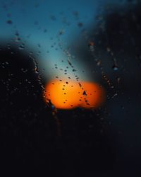 Close-up of raindrops against sky during sunset