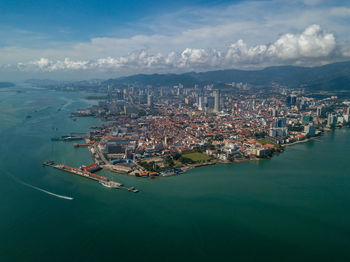 High angle view of cityscape and bay against sky