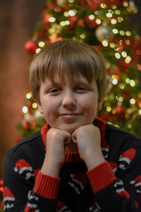 Portrait of cute boy in front of christmas tree 