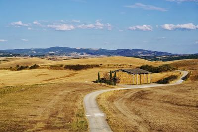 Road leading towards mountains against sky