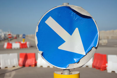 Close-up of directional sign against blue sky