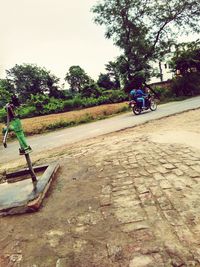 Man on road against trees