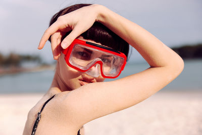 Low section of woman wearing hat standing at beach