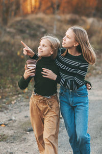 The two sisters return from school and talk as they drive through an open-air autumn park.