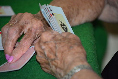 Senior woman playing cards at table