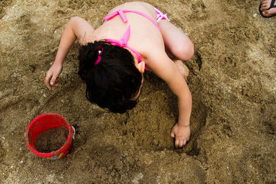 High angle view of girl playing on sand at beach