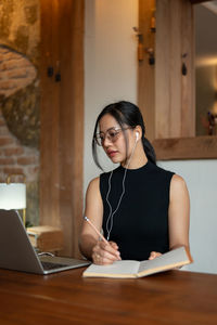 Young woman using laptop at table