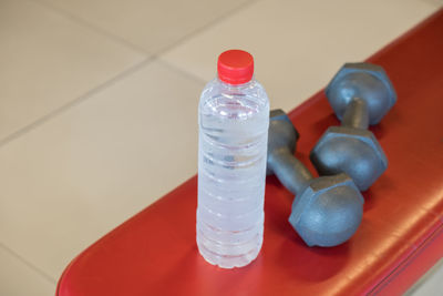 High angle view of bottle and dumbbell on table