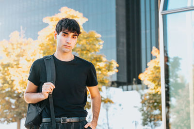 Portrait of young man standing in city