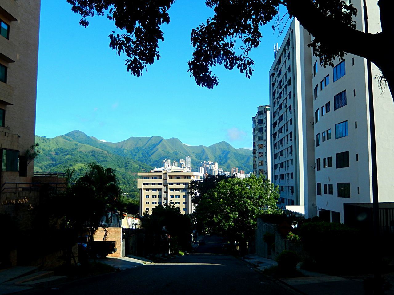 STREET BY BUILDINGS AGAINST SKY