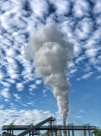 Low angle view of smoke emitting from factory against sky