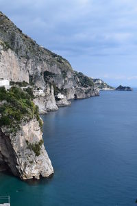 Rock formations by sea against sky