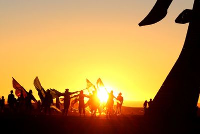 Silhouette people against sky during sunset