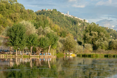 Scenic view of lake by trees against sky