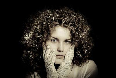 Portrait of beautiful young woman over black background