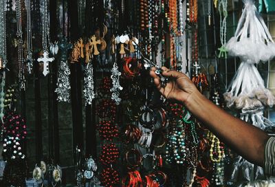 Midsection of person hand touching key ring at market stall