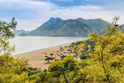 Scenic view of sea and mountains against sky