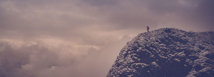 Man in snow covered against sky