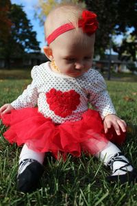 Cute baby girl sitting on grass