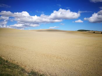 Scenic view of sand dunes against sky