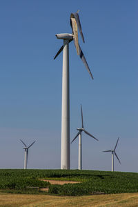 Low angle view of damaged windmill on field against sky during sunny day