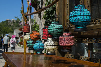 Lanterns hanging over wooden table against building