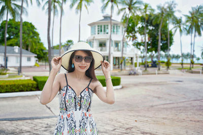 Portrait of young woman wearing sunglasses standing outdoors