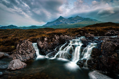 Scenic view of waterfall against sky