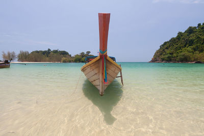 Deck chairs on beach against sky